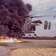An HH-43B participates in an firefighting exercise. The crew of the helicopter uses the rotor downwash to open a path for rescuers to spray foam.